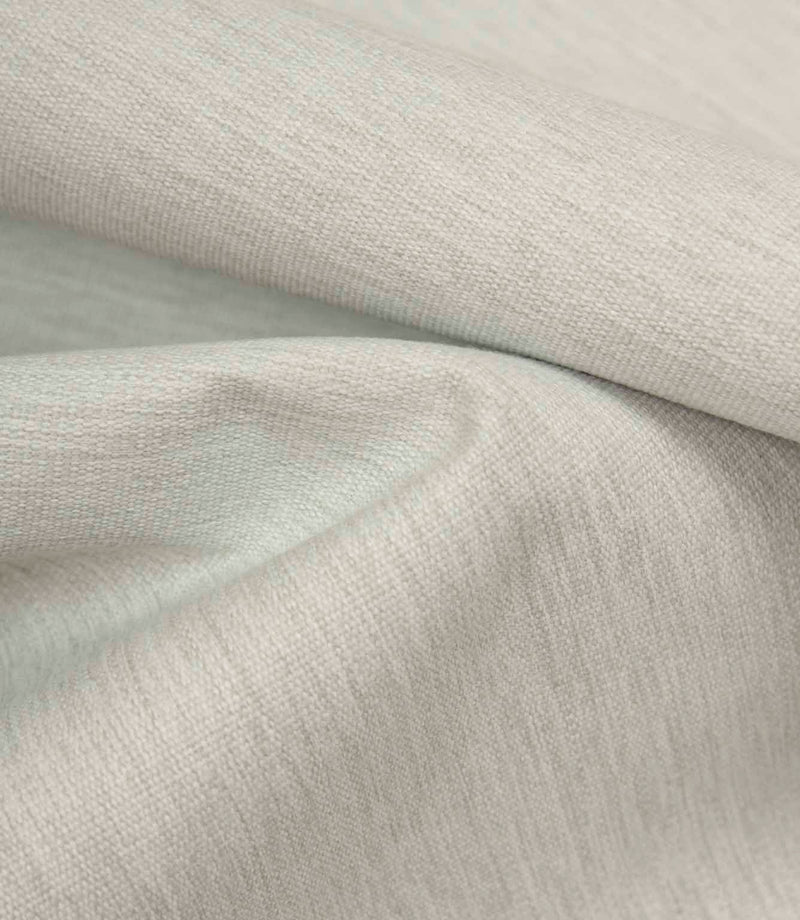 Grey textured fabric draped to highlight softness, movement, and relaxed finish.