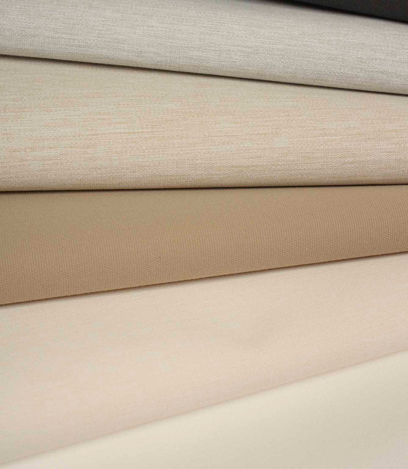 Folded fabric in soft neutral shades including cream, beige and taupe, with a fine, even woven texture.