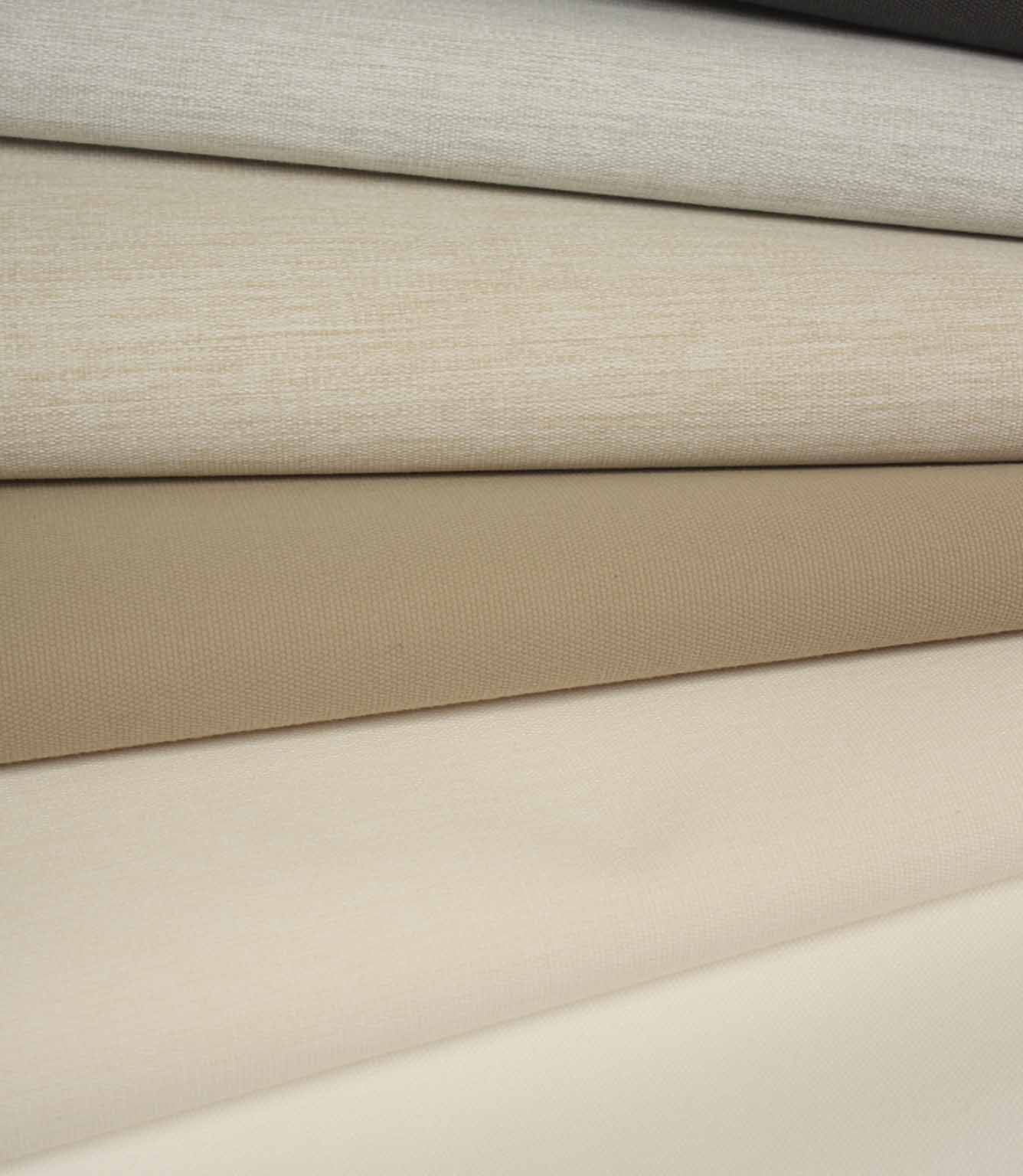 Folded fabric in soft neutral shades including cream, beige and taupe, with a fine, even woven texture.