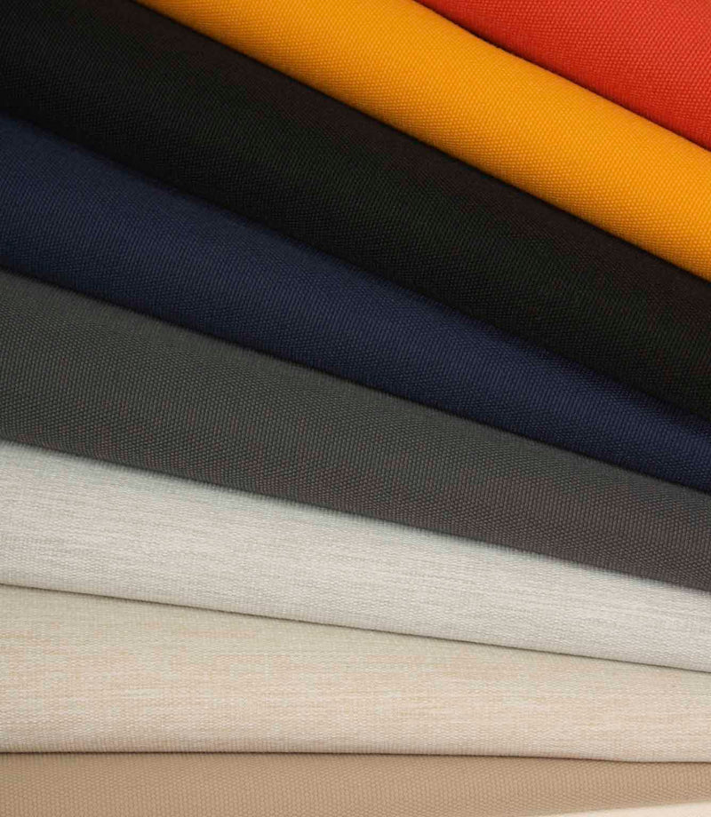 Stacked plain fabrics in cream, stone, grey and navy, highlighting subtle texture and tonal variation.