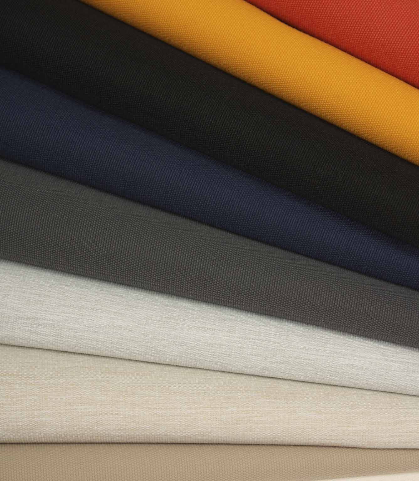 Stacked plain fabrics in cream, stone, grey and navy, highlighting subtle texture and tonal variation.