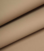 Beige woven fabric folded to show structure, weight, and smooth surface.