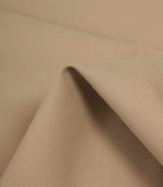 Beige fabric draped over an edge to highlight texture, flexibility, and soft structure.