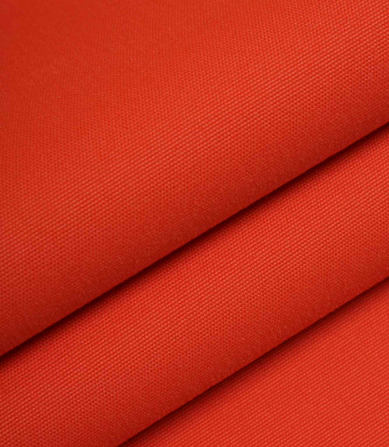Orange woven fabric folded to highlight structure, weight, and surface texture.