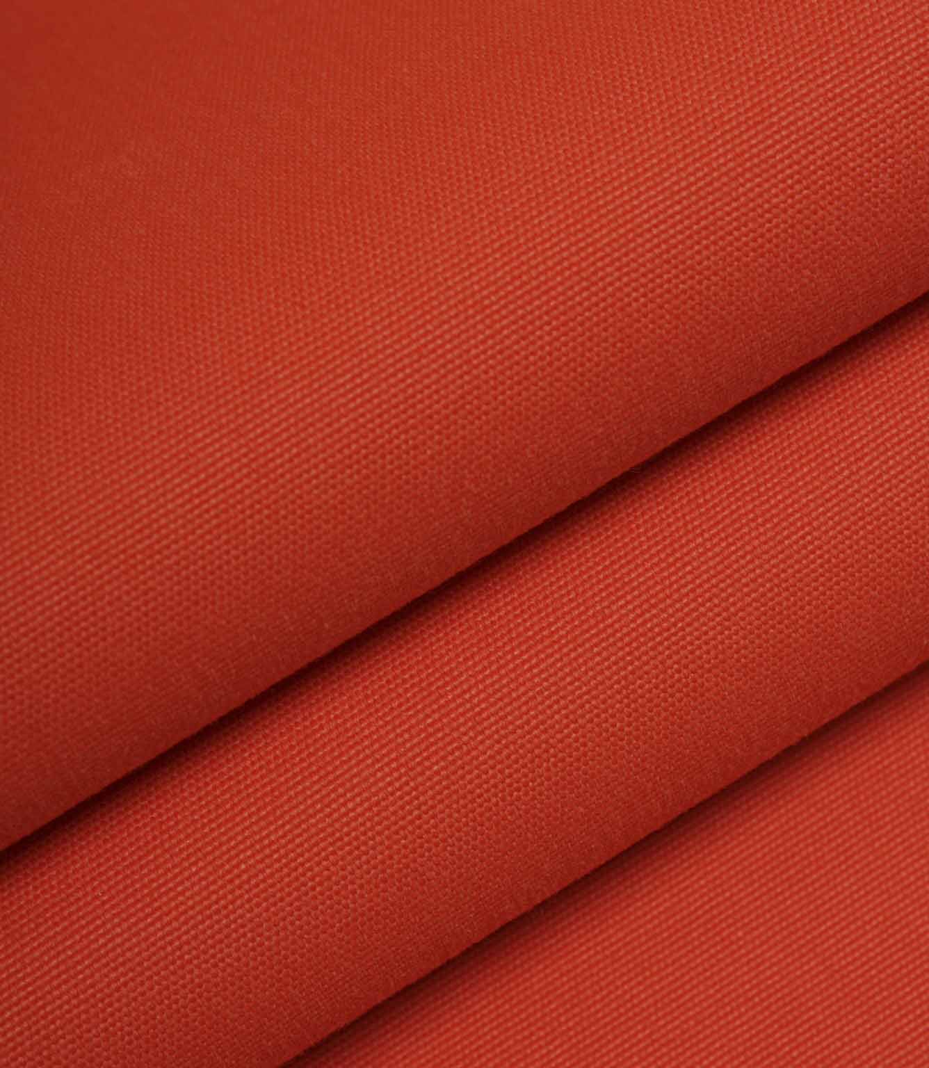 Orange woven fabric folded to highlight structure, weight, and surface texture.