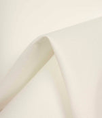 Ivory fabric gently draped to highlight its soft handle, smooth surface, and natural light reflection.