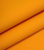 Orange woven fabric folded to show thickness, structure, and smooth surface finish.