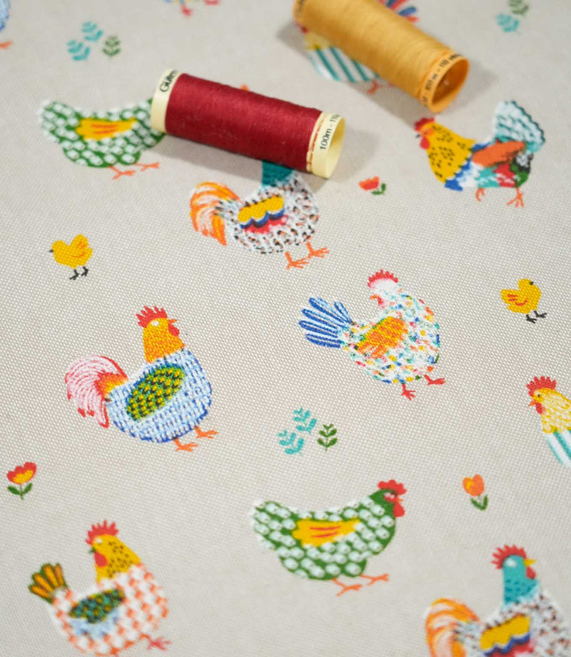 Cottage Hens Multi chicken print fabric with red and yellow thread spools, showcasing colourful country-style hens, roosters and chicks.