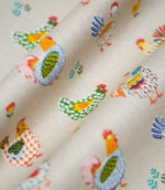 Cottage Hens Multi fabric arranged in soft folds, highlighting its colourful farmyard chicken pattern and natural-looking woven texture.