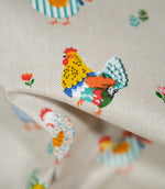 Detailed close-up of Cottage Hens Multi fabric featuring a brightly coloured rooster with yellow, orange, blue and green feathers on a neutral background.