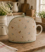 Tea cosy with chicken pattern fabric in a country kitchen on a wooden surface