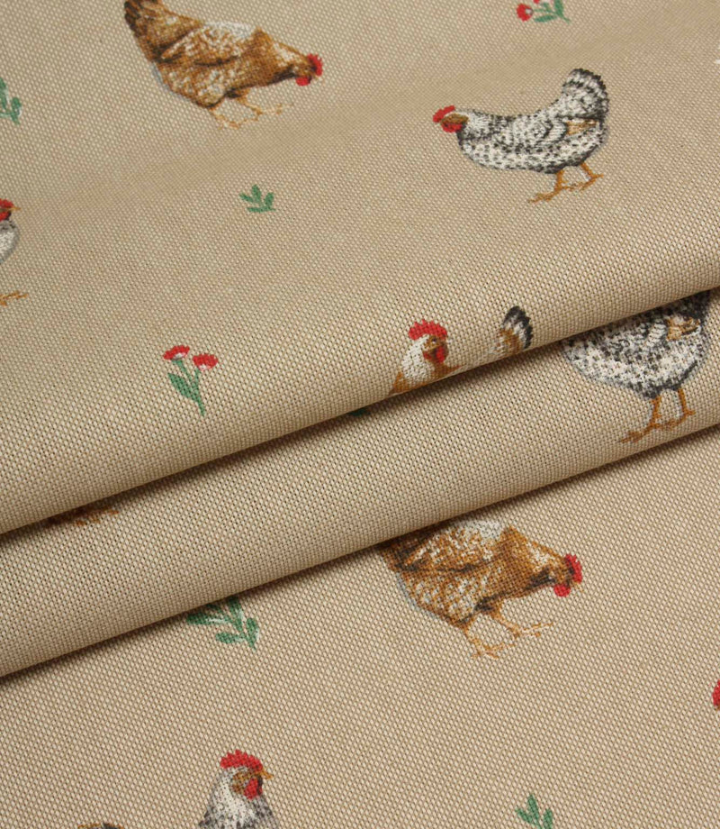 Folded country print fabric featuring scattered hens and tiny floral details on a warm natural background.