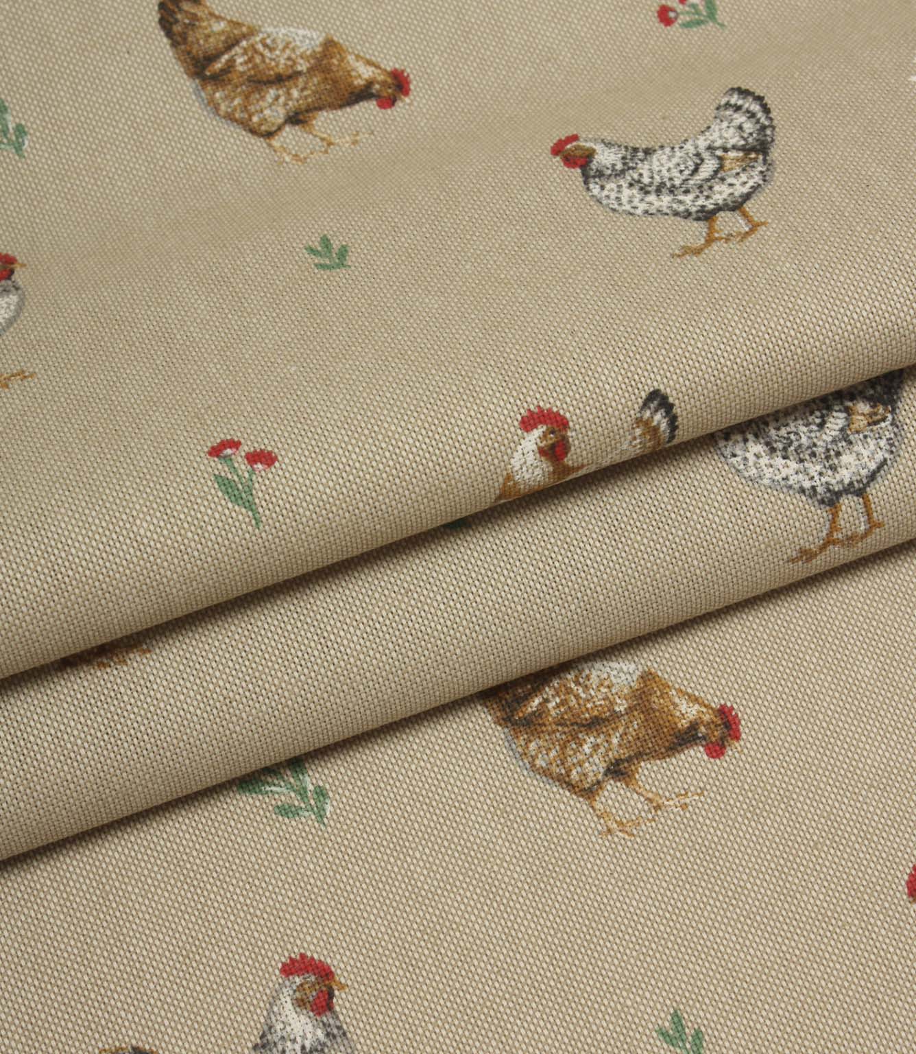 Folded country print fabric featuring scattered hens and tiny floral details on a warm natural background.