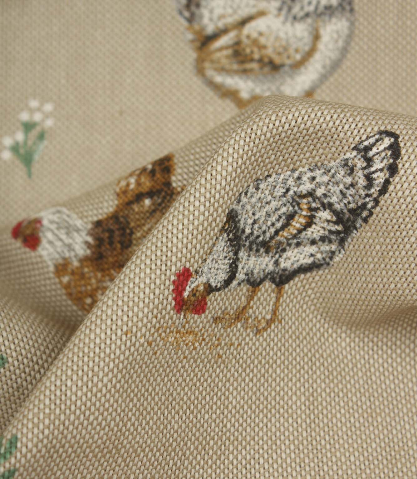 Close-up textured fabric featuring black and white hens with red comb details on a soft natural beige woven background.