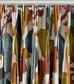 Close-up of Elaris Fabric Auburn curtains with a bold abstract botanical design in burnt orange, teal blue, olive green, rust and charcoal on a natural cream background.