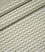 Elkstone Matcha woven fabric arranged in soft, overlapping folds, displaying its repeating olive green geometric pattern and textured cream surface.