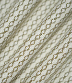 Detailed view of Elkstone Matcha fabric gathered into flowing folds, highlighting the raised woven texture and repeating olive green geometric design.