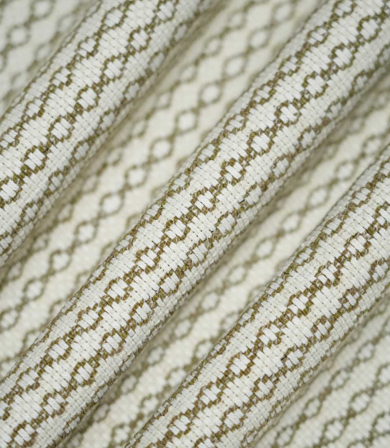 Detailed view of Elkstone Matcha fabric gathered into flowing folds, highlighting the raised woven texture and repeating olive green geometric design.