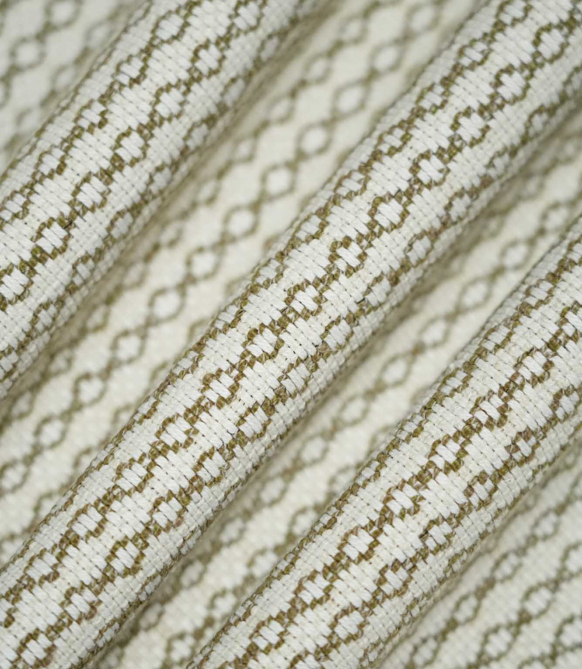 Detailed view of Elkstone Matcha fabric gathered into flowing folds, highlighting the raised woven texture and repeating olive green geometric design.