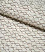 Close-up of folded Elkstone Taupe fabric showing its chunky woven texture, raised cream yarns and repeating taupe geometric motifs.