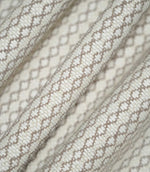 Detailed view of Elkstone Taupe fabric gathered into soft folds, highlighting its tactile woven texture and small-scale geometric design in taupe and cream.