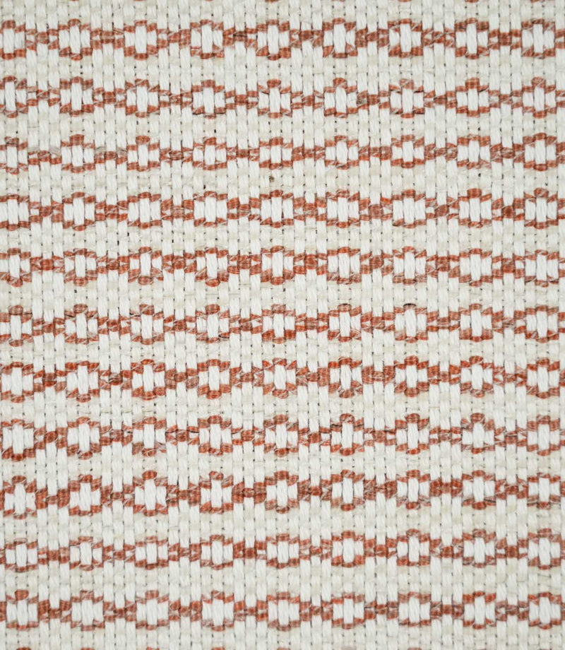 Close-up of Elkstone Terracotta upholstery fabric featuring a textured natural cream weave with repeating terracotta geometric motifs arranged in narrow horizontal rows.