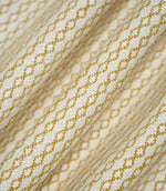 Detailed view of Elkstone Turmeric fabric gathered into soft folds, highlighting its tactile woven texture and small-scale geometric design in mustard yellow and cream.
