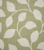 Detailed close-up of Ellerton Apple fabric showing raised cream leaf embroidery connected by delicate curved stems on an apple green woven ground, highlighting the individual stitches, tactile embroidery and subtle texture of the base fabric.