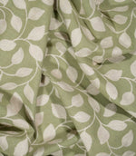 Ellerton Apple embroidered fabric loosely draped into soft folds, showing the repeating cream foliage design flowing across an apple green ground and demonstrating the fabric's natural drape and textured finish for curtains, blinds, cushions and decorative upholstery.