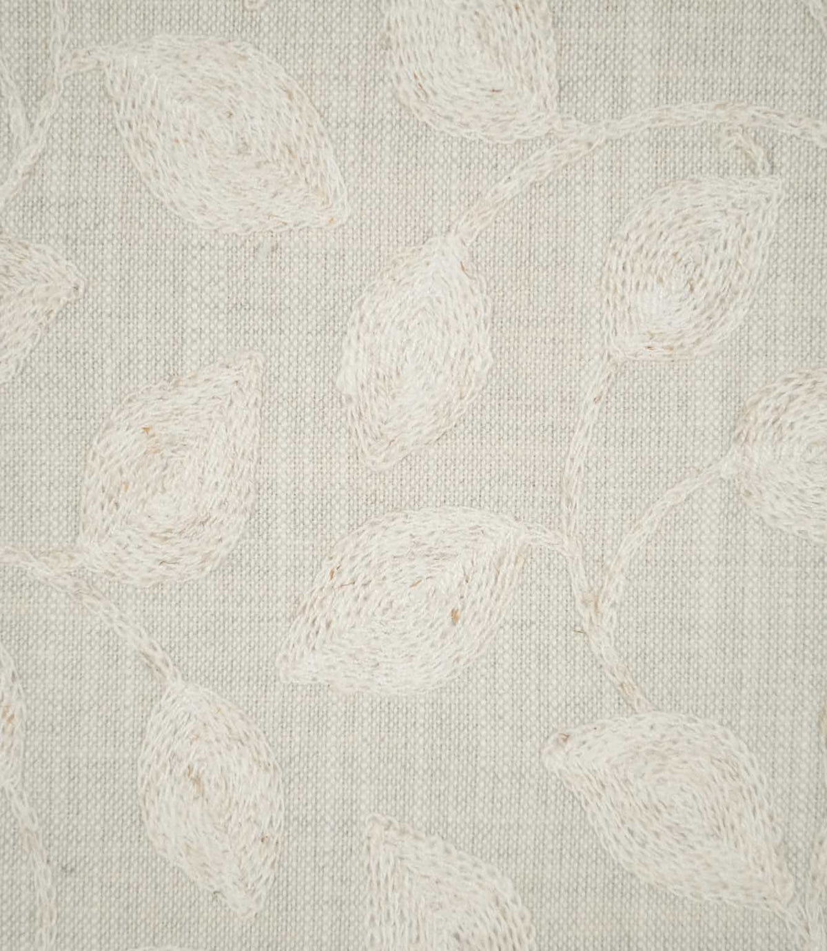 Detailed close-up of Ellerton Cloud fabric showing raised ivory embroidered leaves connected by slender, curving stems on a pale cloud-grey woven ground, highlighting the individual stitches, softly textured weave and tactile finish of the botanical embroidery.