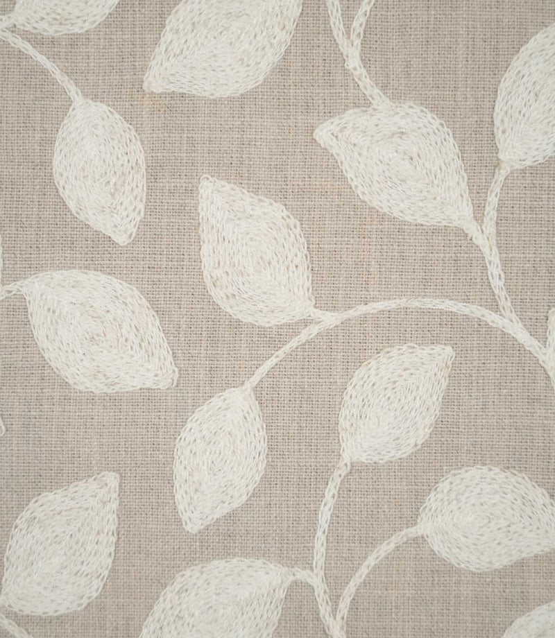Close-up of Ellerton fabric showing raised cream embroidered leaves connected by delicate trailing stems on a natural beige woven ground, highlighting the detailed stitching and textured finish.