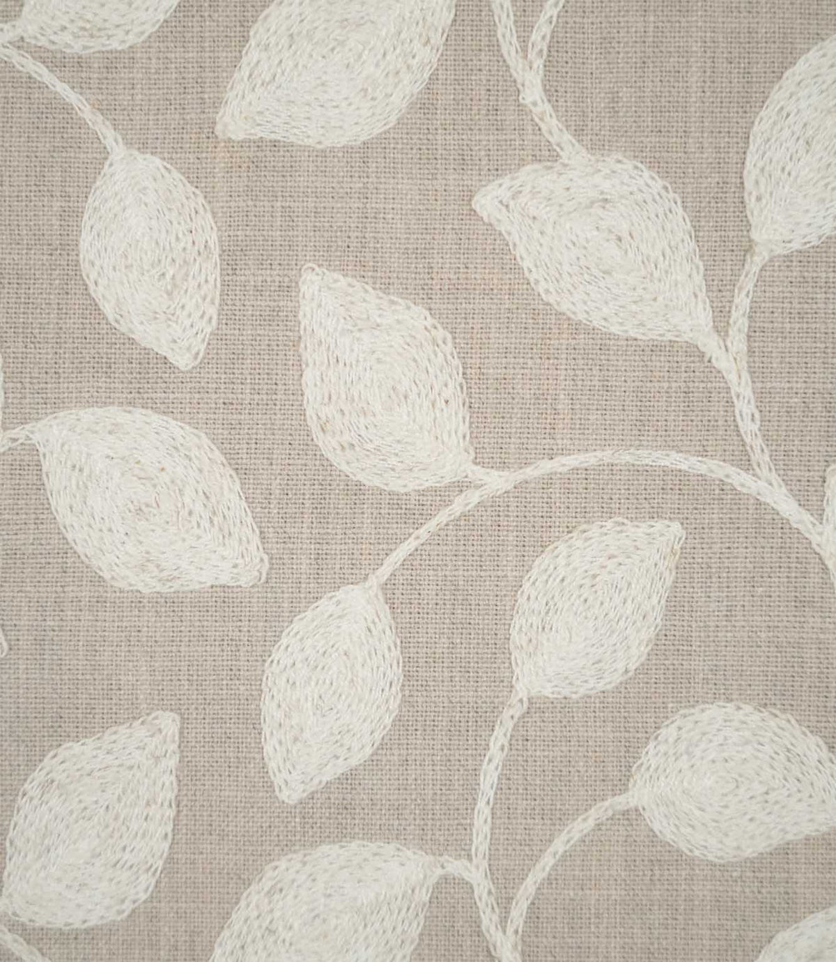 Close-up of Ellerton fabric showing raised cream embroidered leaves connected by delicate trailing stems on a natural beige woven ground, highlighting the detailed stitching and textured finish.