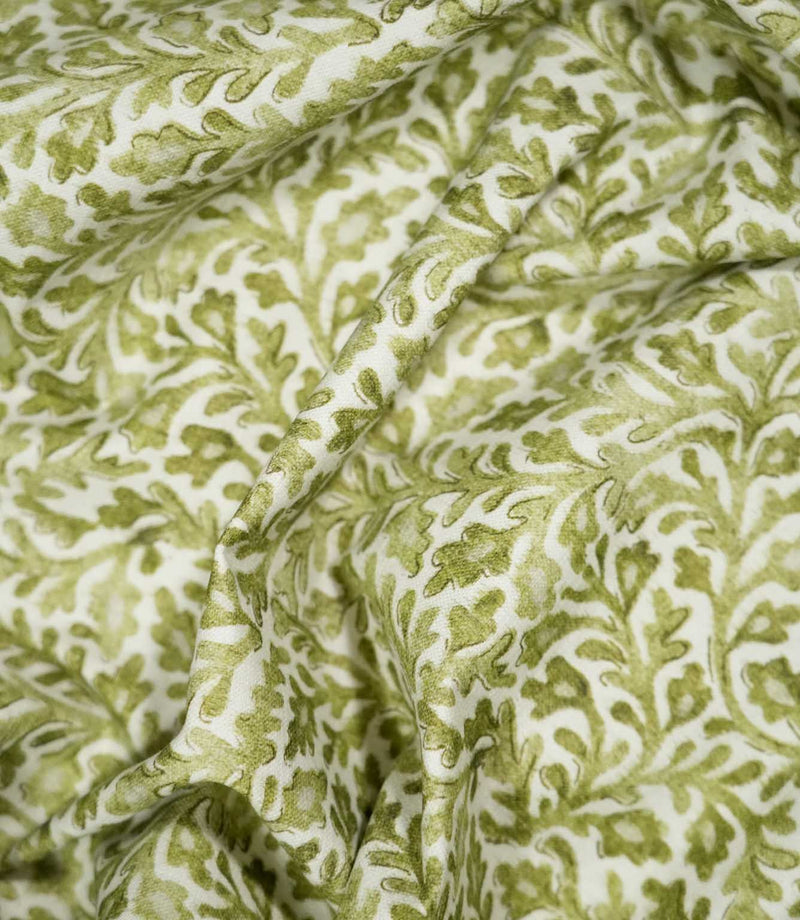 Elmsley Green sustainable fabric loosely draped into soft flowing folds, showing how the small-scale green floral and foliage pattern falls naturally when used for curtains, Roman blinds, cushions or soft furnishings.