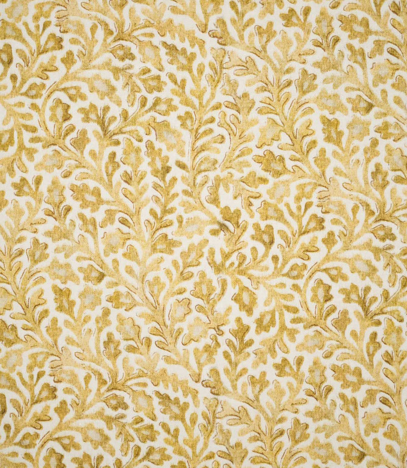 Elmsley Ochre fabric shown flat, featuring a small-scale botanical pattern of flowing foliage, leafy stems and stylised floral forms in layered ochre, mustard and soft golden tones on a warm off-white ground.