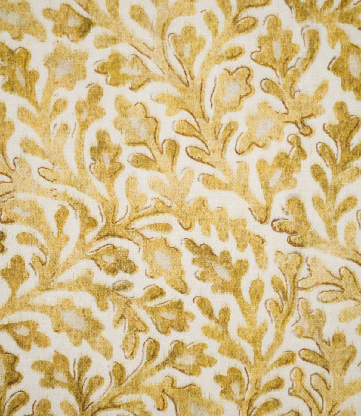 Detailed close-up of Elmsley Ochre fabric showing the hand-rendered character of the small-scale floral and foliage design, with softly mottled ochre leaves, delicate darker outlines and branching botanical forms on an off-white background.