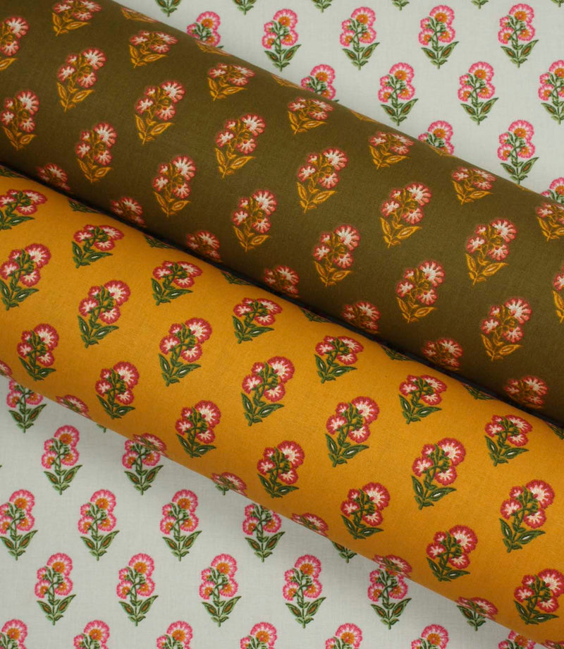 Coordinating botanical fabrics in soft ivory, warm ochre, and olive tones, each printed with small pink floral sprigs in a neat repeating pattern.