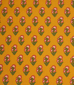 Mustard yellow fabric featuring a repeating floral sprig pattern with pink and white blooms and green foliage.