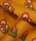 Close-up detail of mustard floral fabric highlighting the woven texture and stylised botanical print.