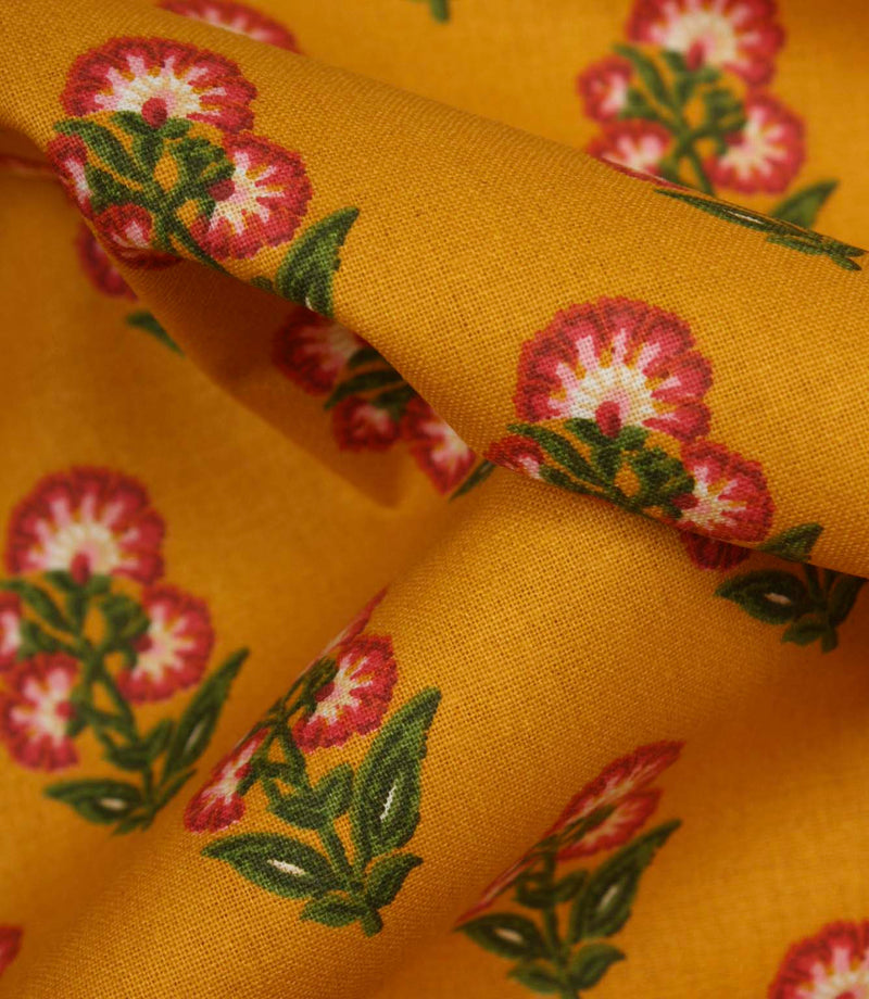Close-up detail of mustard floral fabric highlighting the woven texture and stylised botanical print.