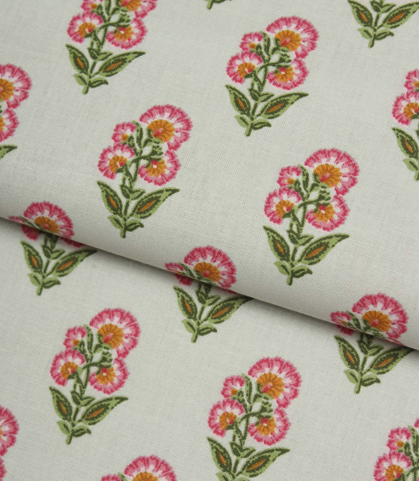 Folded floral print fabric with small-scale pink flowers and soft green leaves on a fresh light cream background.