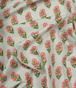 Draped botanical fabric featuring scattered pink floral sprigs in a neat repeating pattern on an ivory base.