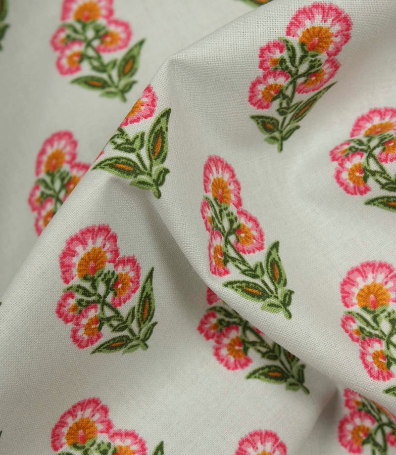 Close-up of lightweight floral fabric showing detailed pink and orange flower heads with green foliage on a smooth woven texture.