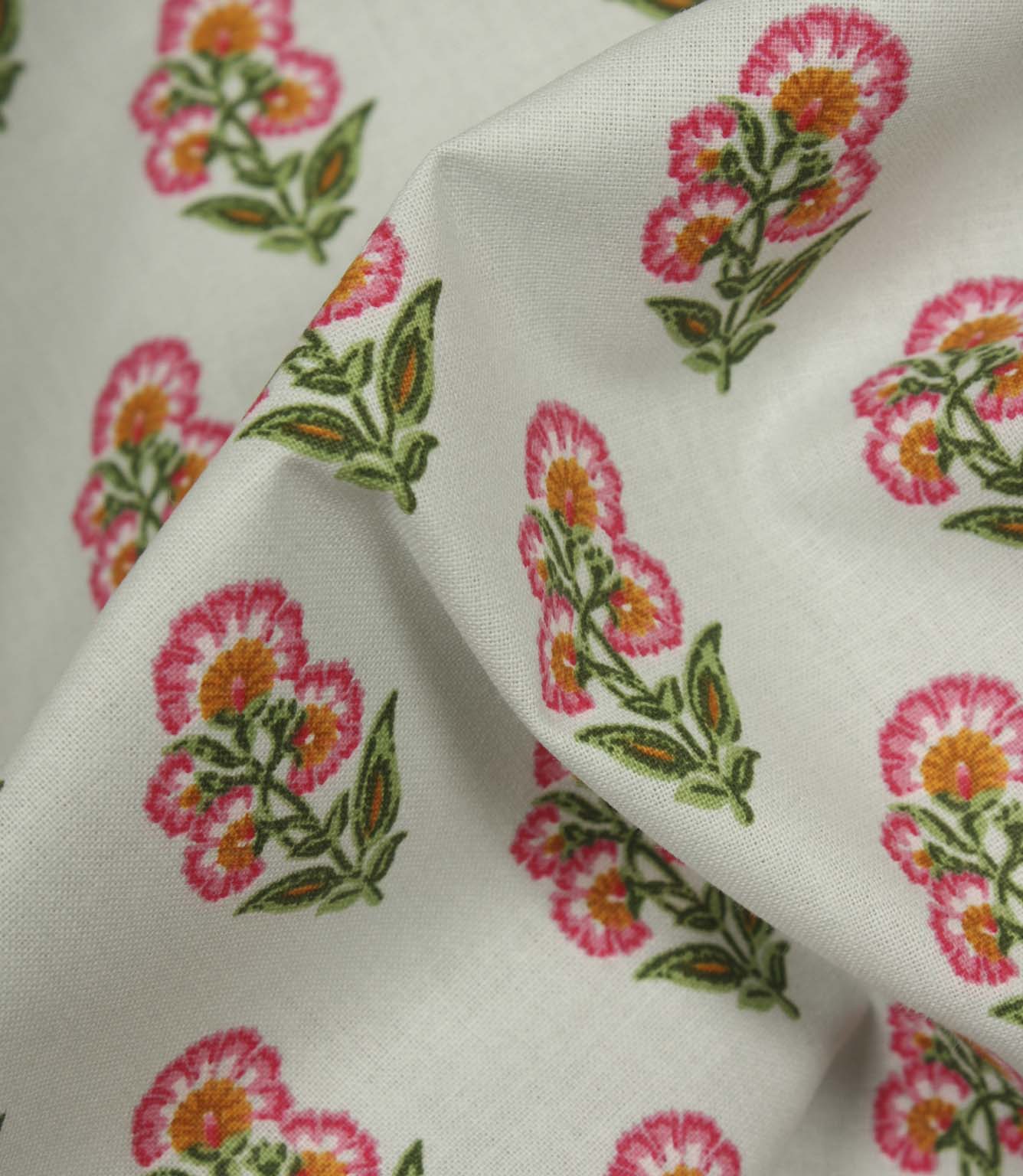 Close-up of lightweight floral fabric showing detailed pink and orange flower heads with green foliage on a smooth woven texture.