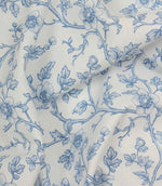 Draped blue and ivory floral fabric with flowing trailing stems and soft botanical motifs.