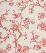 Close-up of red floral fabric showcasing intricate botanical linework, delicate blossoms, and fine woven texture on an ivory base.