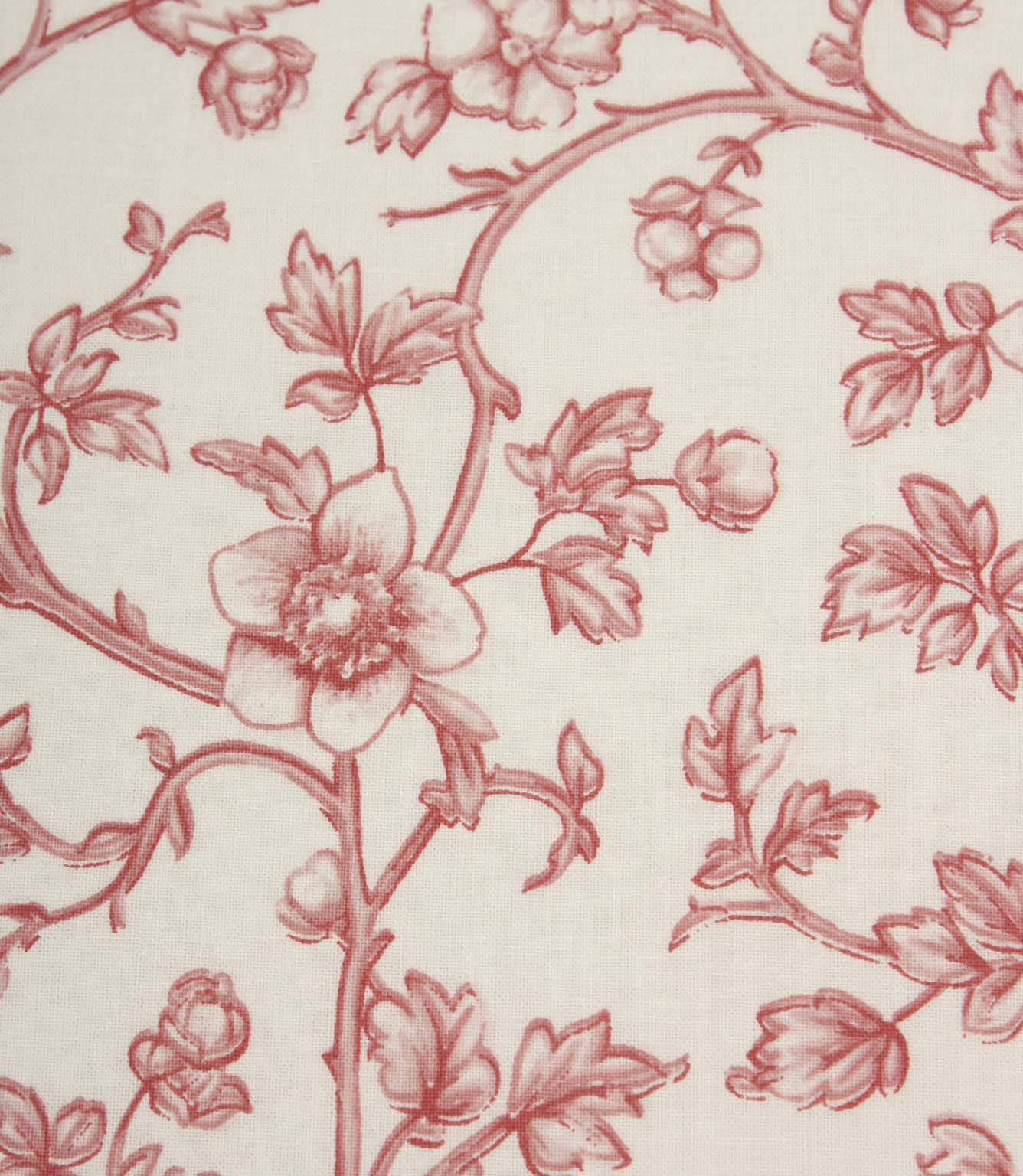 Close-up of red floral fabric showcasing intricate botanical linework, delicate blossoms, and fine woven texture on an ivory base.