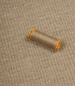 Everleigh Pebble upholstery fire retardant fabric with coordinating thread, highlighting the soft-touch texture and woven plain design.
