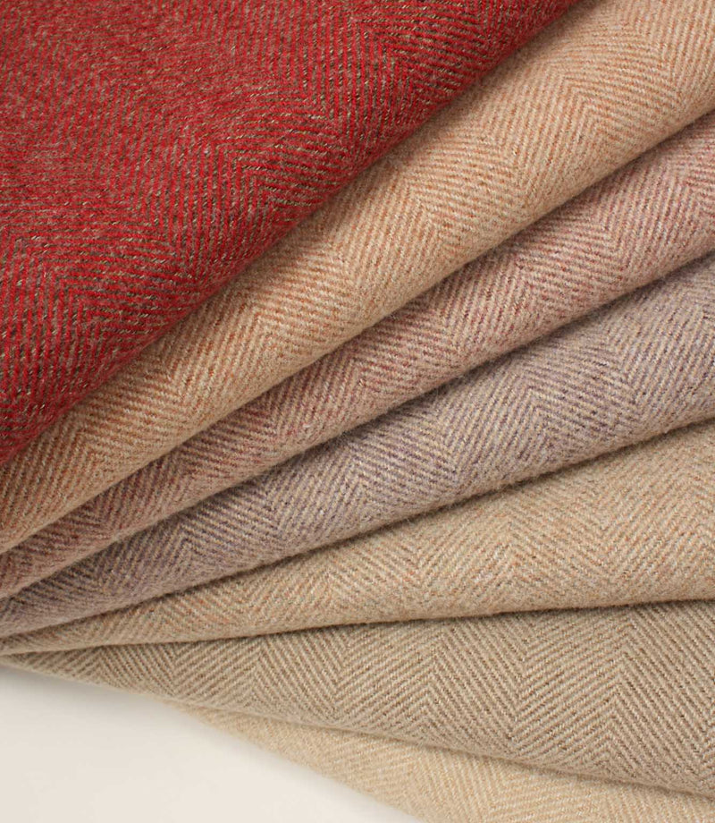Stack of herringbone-patterned fabric in red and beige tones.
