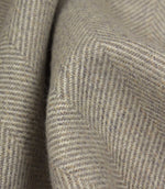 Close-up of grey herringbone pattern fabric with a focus on texture and colour.