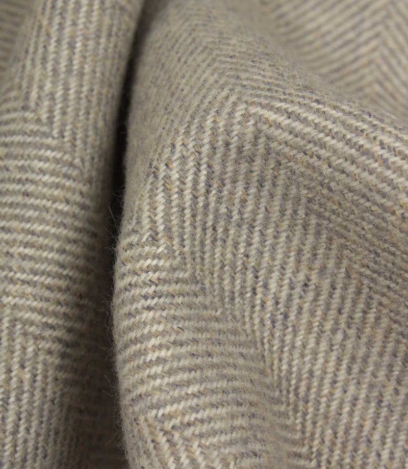 Close-up of grey herringbone pattern fabric with a focus on texture and colour.